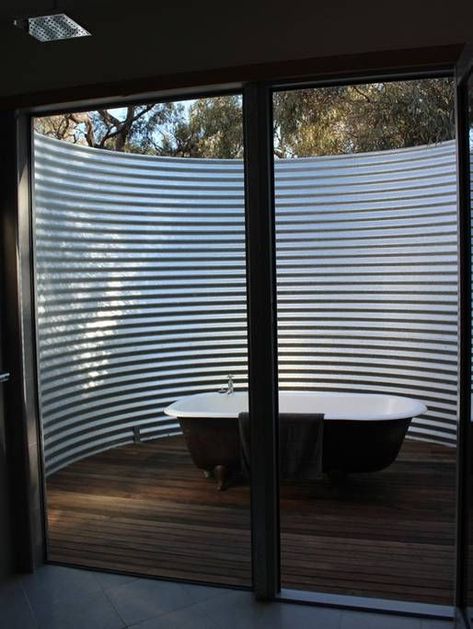 outdoor bathtub surrounded by corrugated curved steel sheet